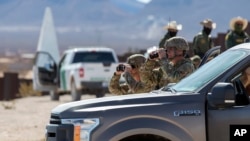 Soldados del Ejército usan binoculares mientras brindan seguridad a la visita del secretario de Defensa, Pete Hegseth, a la frontera entre Estados Unidos y México en Sunland Park, Nuevo México, el lunes 3 de febrero de 2025. (Foto AP/Andres Leighton)