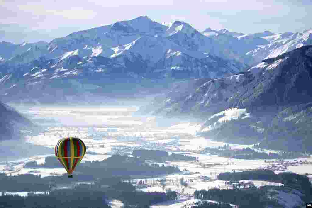 A hot air balloon floats above Zell am See, Austria.