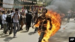 A Tibetan man screams as he runs engulfed in flames after self-immolating at a protest in New Delhi, India, ahead of Chinese President Hu Jintao's visit to the country Monday, March 26, 2012. The Tibetan activist lit himself on fire at the gathering and w