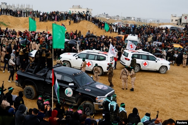 Palestinian militants and members of the Red Cross gather near vehicles on the day Hamas hands over deceased Israeli hostages to the Red Cross, in Khan Younis in the southern Gaza Strip, Feb. 20, 2025.