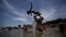 People play at an artificial pond known as piscinao, or big pool, in the northern suburbs of Rio de Janeiro, Brazil, Jan. 8, 2017.