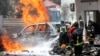 FILE - Somali firemen try to extinguish burning cars at the scene where a car bomb exploded in front of a restaurant in Mogadishu, Somalia, Jan. 29, 2019. 