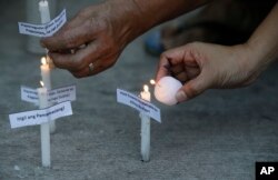 Aktivis menyalakan lilin saat mereka berdoa pada Senin, 1 April 2019, di Manila, Filipina, untuk memprotes pembunuhan di Filipina tengah sebagai ilustrasi. (Foto: AP)