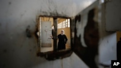 A woman examines the cells at the infamous Saydnaya military prison, just north of Damascus, Syria, on Dec. 9, 2024. Crowds are gathering to enter the prison after thousands of inmates were released following rebels' overthrow of Bashar al-Assad's regime.