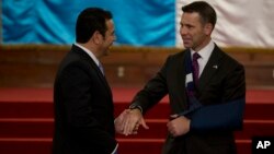 El secretario interino del Departamento de Seguridad Nacional de EE.UU., Kevin McAleenan (derecha), y el presidente de Guatemala, Jimmy Morales, se dan la mano en el Palacio Nacional de la Ciudad de Guatemala, el lunes 27 de mayo de 2019. (Foto AP / Moises Castillo)