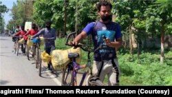 Pekerja migran India naik sepeda dalam perjalanan mudik ke kampung halaman mereka selama diberlakukannya pembatasan akibat pandemi COVID-19 tahun 2020. (Foto: Bhagirathi Films / Thomson Reuters Foundation)