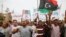 FILE - Protesters wave a Libyan flag as they demonstrate in Martyrs' Square demanding deposed Libyan dictator Moammar Gadhafi -era officials be banned from taking up political posts, in Tripoli, May 5, 2013.