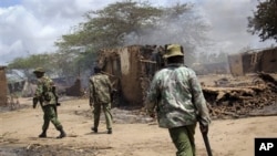 Polisi Kenya melakukan patroli melewati rumah-rumah yang hangus terbakar di desa Nduru, pasca terjadinya bentrokan antara para petani dan penggembala ternak di Sungai Tana, Kenya bagian tenggara, September lalu (Foto: dok). Sedikitnya 28 orang tewas dalam bentrokan etnis yang kembali terjadi di wilayah ini, Jum'at (21/12). 