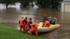 Para petugas membantu seorang dokter gigi mengunjungi pasiennya yang terjebak banjir dari permukiman Windsor ke North Richmond di tengah banjir yang melanda Kota Sydney, Australia, Senin, 22 Maret 2021. (Foto: Loren Elliott/Reuters)