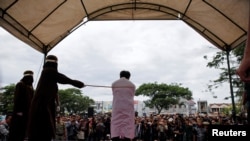 Seorang pria dicambuk di depan umum karena melakukan hubungan seks sesama jenis di Banda Aceh, Aceh, 23 Mei 2017.