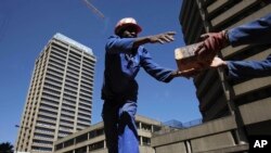 Workers transfer bricks at a construction site in Johannesburg, South Africa. 