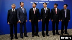 (L-R) Bank of Japan Governor Haruhiko Kuroda, Japanese Finance Minister Taro Aso, South Korean Finance Minister Yoo Il-ho, Bank of Korea Governor Lee Ju-yeol, Chinese Vice Minister of Finance Yaobin Shi gather before a trilateral meeting on the sideline of Asian Development Bank's annual meeting in Yokohama, Japan, May 5, 2017. 