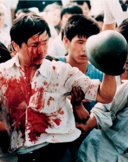 FILE - A blood-covered protester holds a Chinese soldier's helmet following violent clashes with military forces during the 1989 pro-democracy demonstrations in Beijing's Tiananmen Square in this June 4, 1989 photo.