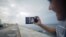 Artist Dariel Llerandis, 31, shows his wife and his 6-month-old daughter who live in Miami, as he speaks to them using the internet at a Wi-Fi hotspot in Havana, Sept. 22, 2015.