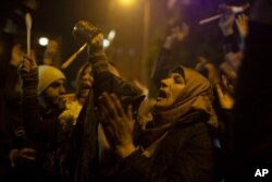 Anti-government protesters chant slogans outside of the residence of Hassan Diab, Lebanon's prime ninister designate, Dec. 28, 2019, in Beirut.