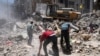 Peralatan konstruksi digunakan untuk menyaring puing-puing sebelum diangkut dari lokasi bangunan yang hancur dalam serangan udara sebelum gencatan senjata yang menghentikan perang 11 hari antara penguasa Hamas Gaza dan Israel, 27 Mei 2021, di Gaza Kota. (Foto: AP)