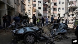 Para petugas tanggap darurat membereskan reruntuhan di lokasi yang menjadi target serangan Israel di pinggiran Kota Beirut, Lebanon, pada 22 September 2024. (Foto: AP/Bilal Hussein)