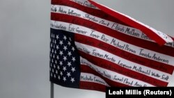 Un drapeau américain à l'envers montrant les noms des personnes de couleur tuées par la police flotte avant une marche de protestation, à Brooklyn Center, Minnesota, États-Unis, le 13 avril 2021. 