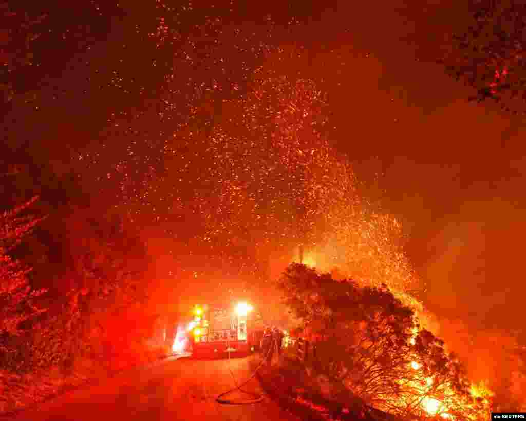 Firefighters battle flames off Highway 154 north of Santa Barbara, California, Nov. 25, 2019, in this picture obtained from social media. (Credit: Mike Eliason/Santa Barbara County Fire Department) 