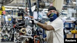 FILE - A person works on a Polaris snowmobile assembly line at their manufacturing and assembly plant in Roseau, Minnesota, June 7, 2021.