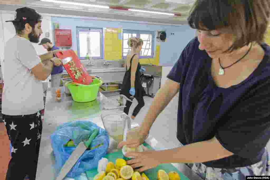 Hassan Mansour, far left, acts as chef to serve daily meals at the Khora center, in the Exarchia district in Athens, Greece, Oct. 24, 2016. The center often provides Syrian food, a welcome relief from the boiled potatoes and pasta often served in camps.