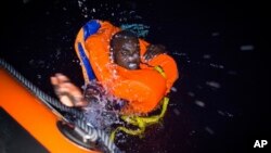 Un migrant nage vers un navire de sauvetage au large des côtes libyennes, dans la nuit du 2 août 2018.