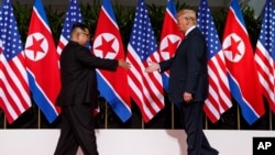 지난 2018년 6월 12일 싱가포르에서 열린 첫 미-북 정상회담에서 도널드 트럼프 미국 대통령과 김정은 북한 국무위원장이 악수를 하기 위해 서로에게 손을 내밀고 있다.