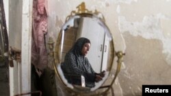 Una mujer palestina, Umm Al-Abd Ouda, se refleja en un espejo, en medio del conflicto entre Israel y Hamás, en Jabalia, en el norte de la Franja de Gaza, el 26 de agosto de 2024.