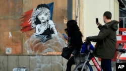 Lukisan gadis kecil dari Les Miserable karya seniman Inggris Banksy di luar Kedutaan Besar Perancis di London. 