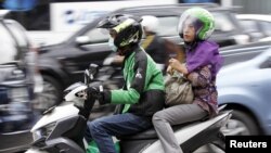 Seorang perempuan menggunakan transportasi online Go-Jek di Jakarta, 5 Desember 2015.