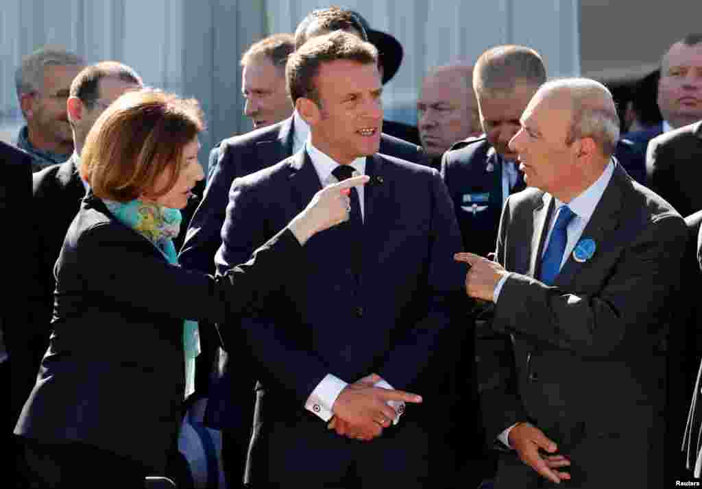 French President Emmanuel Macron, center, French Defense Minister Florence Parly, left, and Eric Trappier, Chairman and CEO of Dassault Aviation, right, attend the 53rd International Paris Air Show at Le Bourget Airport near Paris.