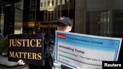 Una mujer sostiene pancartas frente a la Trump Tower neoyorquina, días después de que el expresidente de EEUU, Donald Trump, afirmara que esperaba ser arrestado y pedía a sus seguidores que protestaran en Nueva York, el 22 de marzo de 2023