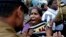 Sri Lankan policemen try to control ethnic Tamil people, whose relatives are missing, during a protest outside a public library where British Prime Minister David Cameron was meeting Tamil leaders, in Jaffna, northern Sri Lanka, Nov.15, 2013.