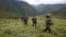 FILE - Members of the 51st Front of the Revolutionary Armed Forces of Colombia (FARC) patrol in the remote mountains of Colombia, Aug. 16, 2016. 