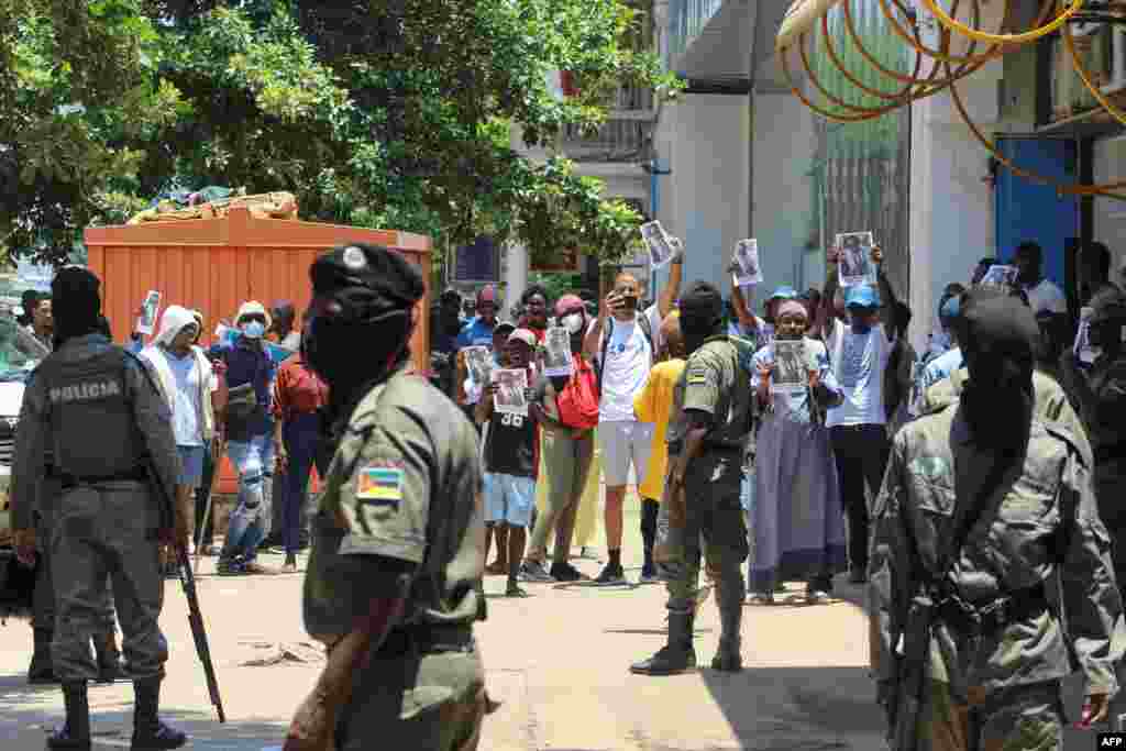 Polícia da República de Moçambique e manifestantes com cartazes do líder da oposição moçambicana Venâncio Mondlane em Maputo, a 15 de Janeiro de 2025, enquanto Daniel Chapo toma  posse como Presidente de Moçambique no dia 15 de janeiro de 2025.