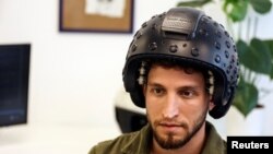 A worker at the Israeli startup Brain.Space shows an electroencephalogram (EEG) enabled helmet, due to be used in an experiment on the effects of a microgravity environment on the brain activity of astronauts, in Tel Aviv, Israel on March 23, 2022. (REUTERS/Nir Elias)