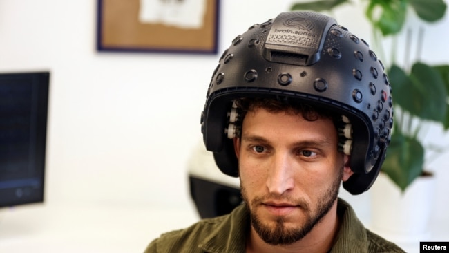 A worker at the Israeli startup Brain.Space shows an electroencephalogram (EEG) enabled helmet, due to be used in an experiment on the effects of a microgravity environment on the brain activity of astronauts, in Tel Aviv, Israel on March 23, 2022. (REUTERS/Nir Elias)