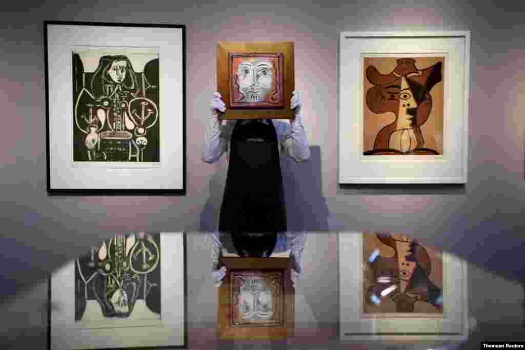 영국 런던의 크리스티 옥션 하우스 직원이 피카소의 그림을 들고 있다. 