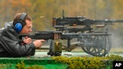 FILE - Russian Prime Minister Dmitry Medvedev shoots as he visits a factory, producing weapons components in Klimovsk outside Moscow on Wednesday, Oct. 3, 2012.