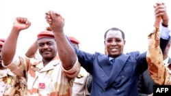 Le général du contingent tchadien au Mali Oumar Bikimo, à gauche, se tiennent la main avec le président du Tchad Idriss Deby Itno, lors d'une cérémonie de bienvenue, à N'Djamena, le 13 mai 2013.