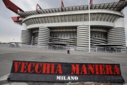 Una pancarta con los colores del AC Milan que dice "Viejo Estilo" luce afuera del estadio San Siro en Milan, Italia, el lunes 19 de abril de 2021.