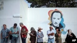 Voters queue outside a polling station during the first round of the presidential election, in La Marsa, outside Tunis, Tunisia, Sunday Sept. 15, 2019. Tunisia is holding a cacophonous presidential election this weekend, with voters choosing among…