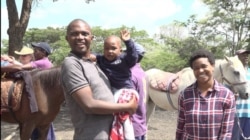 Stanley Dzingai brings his 4-year-old child for regular horse therapy sessions at the Harare site. Nov. 21, 2019. (Columbus Mavhunga/VOA)