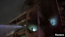 FILE - Water is sprayed on a damaged building at the site of an explosion, in what security sources say is an Israeli drone strike, in the Beirut suburb of Dahiyeh, Lebanon January 2, 2024.