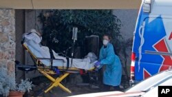 A patient is loaded into an ambulance at the Life Care Center in Kirkland, Wash., March 9, 2020, near Seattle. 