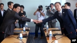 Kim Kiwoong (kanan), pimpinan delegasi Korea Selatan berjabat tangan dengan Park Chol Su pimpinan delegasi dari Korea Utara dalam rapat di Komite Manajemen Kawasan Industri Kaesong di Korea Utara (17/7).