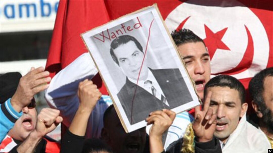 A woman holds a picture of Tunisia's deposed leader Zine El Abidine Ben Ali, reading "Wanted", during a demonstration showing solidarity with Tunisians, in Marseille, southern France , Jan. 15, 2011. Unrest engulfed Tunisia on Saturday after a popular reb