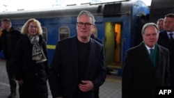 Britain's Prime Minister Keir Starmer, center, is greeted by Ukrainian officials and British ambassador to Ukraine Martin Harris, right, upon arrival at the train station in Kyiv on Jan. 16, 2025.