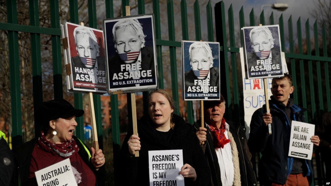 Pendukung Julian Assange memegang spanduk di luar Pengadilan Belmarsh Magistrates di tenggara London, 25 Februari 2020. (Foto: AP)