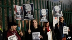 Supporters of Julian Assange hold placards as they protest on the second day of a week of opening arguments for the extradition of Wikileaks founder Julian Assange outside Belmarsh Magistrates' Court in south east London, Feb. 25, 2020. 